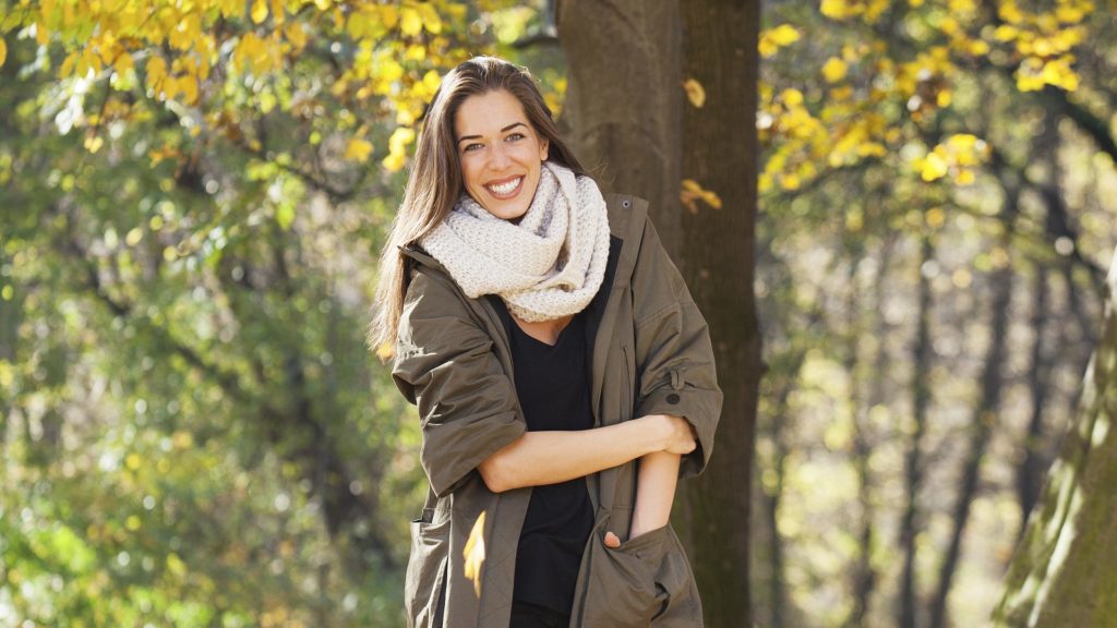 Modelo fotografada em ensaio fotográfico  na Floresta com roupa marrom combinando com a árvore.